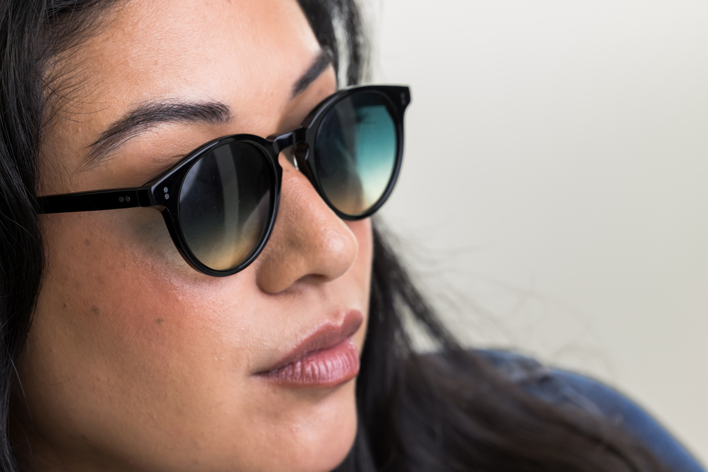female model showcasing Bell. Sunglasses in Black with Lagoon Haze Gradient