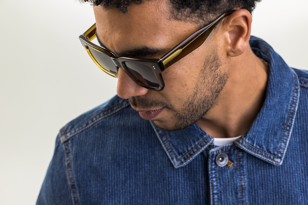 Male model wearing Husk Crystal sunglasses with grey lenses top angle view