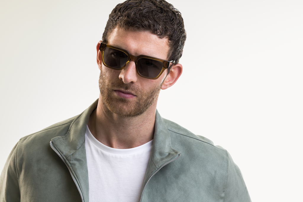 Male model wearing Macrae sunglasses with green lenses front profile