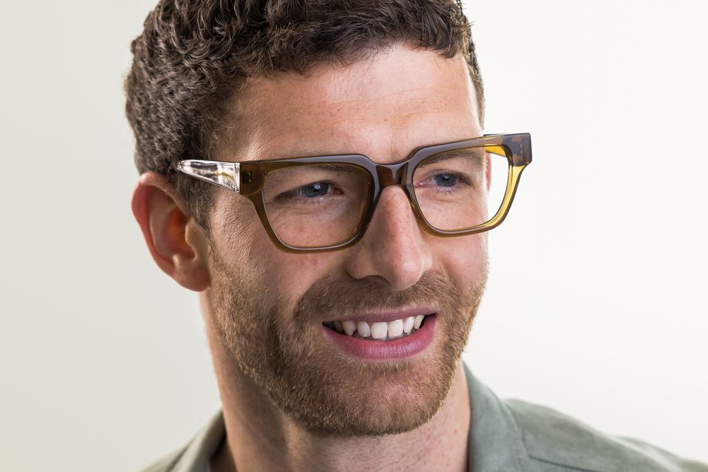 Male model wearing Macrae glasses in husk crystal front smiling view