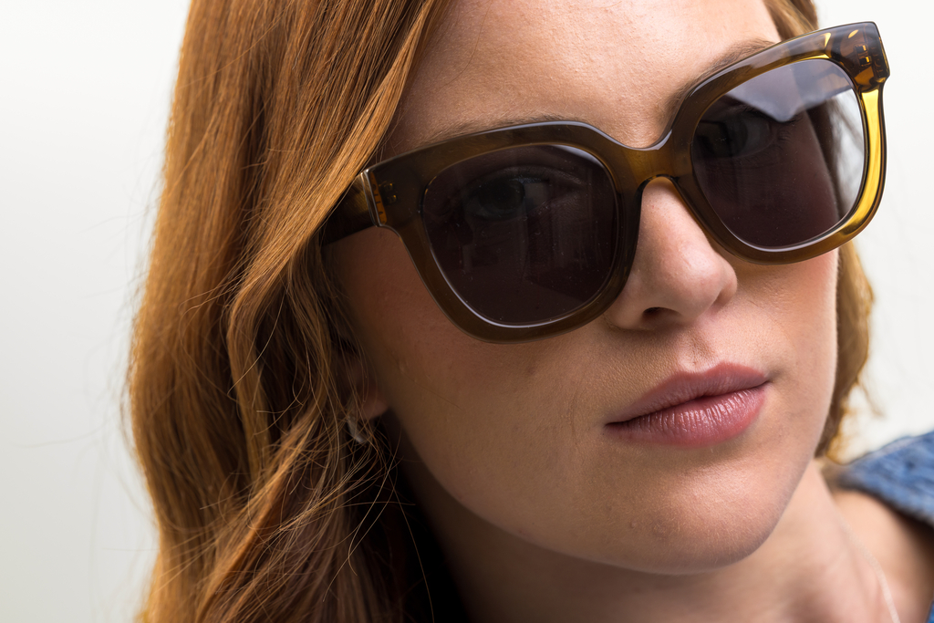 Female model wearing Husk Crystal sunglasses with grey lenses front profile
