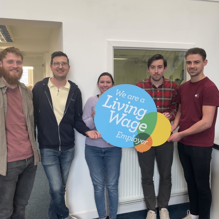 Workshop team IOLLA hold living wage sign