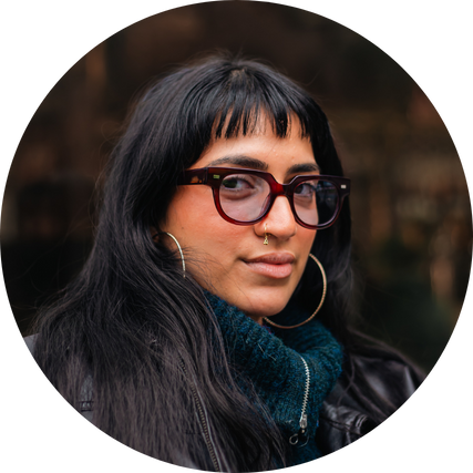 Blue colour tinted lenses in red glasses frame worn on face.png