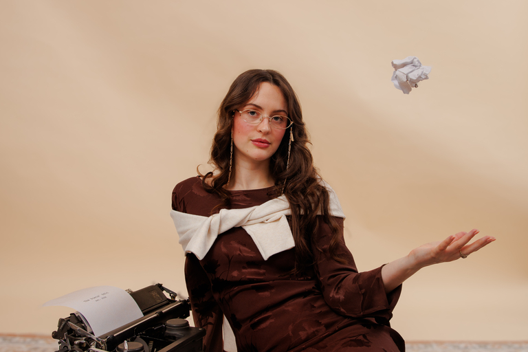 Model wearing gold metal oval glasses with slim wire frame and lightweight design.