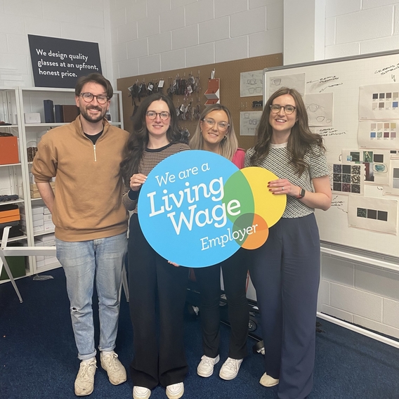 Creative team IOLLA hold living wage sign