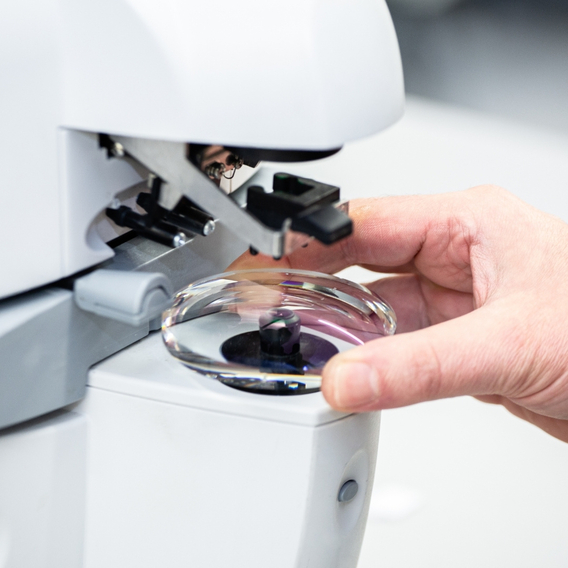 Hand holding lens in machinery