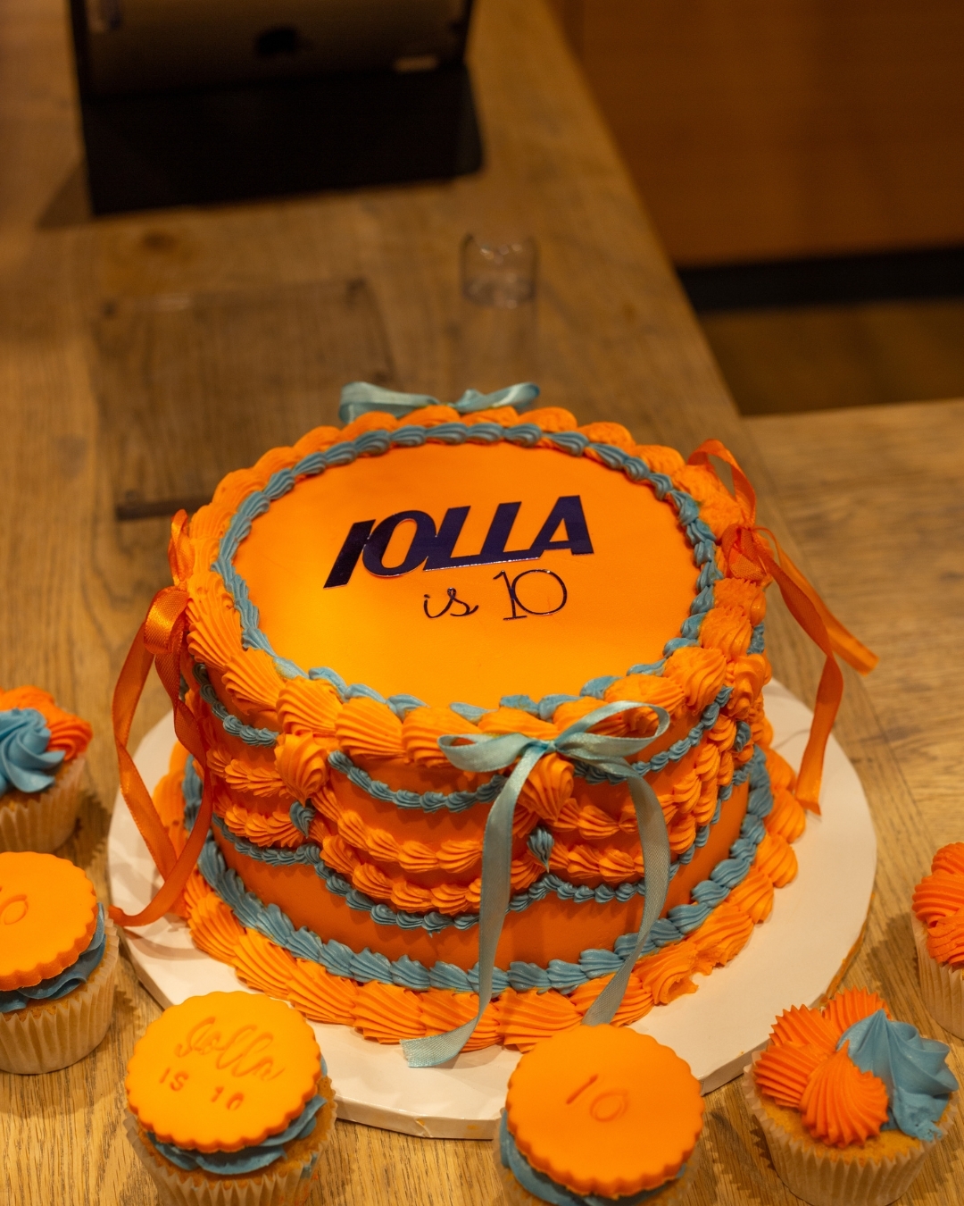 IOLLA 10th Birthday cake in orange and blue with cupcakes