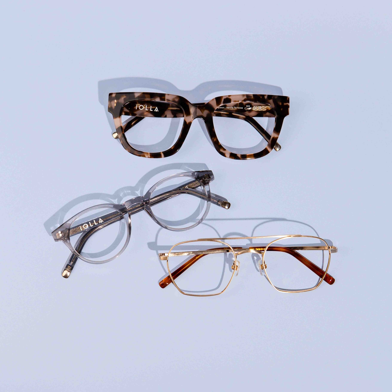 An IOLLA stylist helping a customer try on frames in the showroom