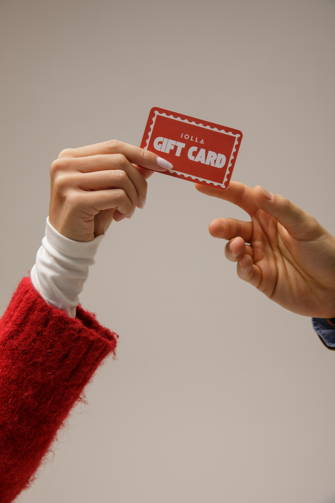 Hands passing an IOLLA gift card as a Christmas present