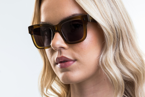 Female model wearing Brodie sunglasses in Husk Crystal with grey lenses side profile