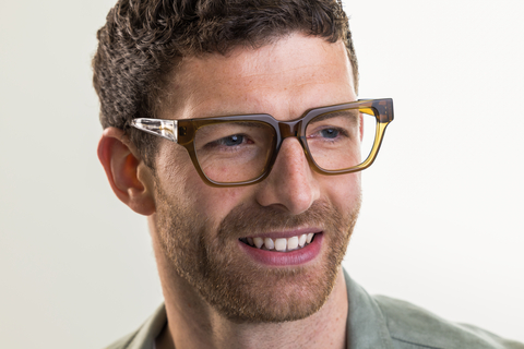 Male model wearing Macrae glasses in husk crystal front smiling view