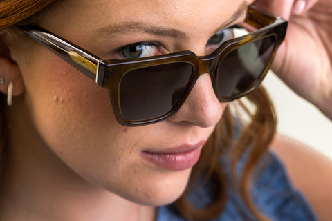 Female model wearing Husk Green Crystal Sunglasses with grey lenses side profile